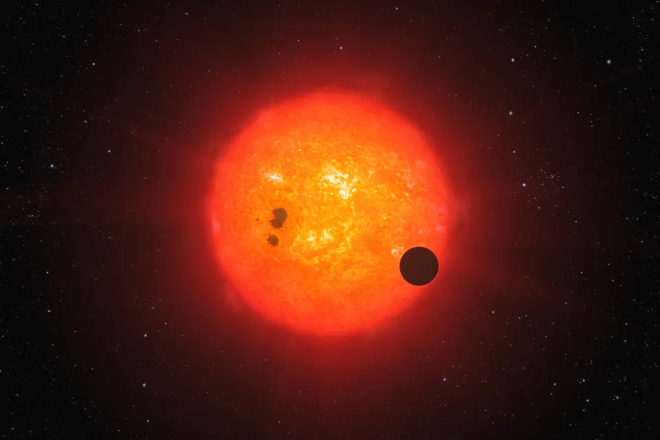 A blue-grey planet with a hazy atmosphere in front of a small red star.