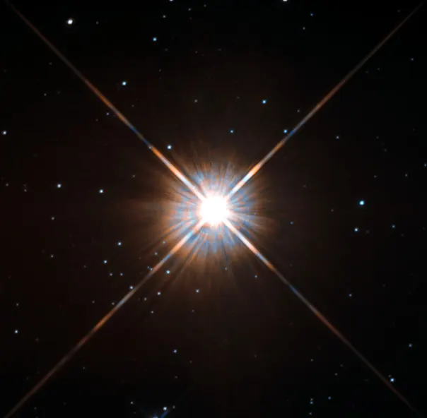 A bright red-white star with four diffraction spikes among a scattering of faint background stars.