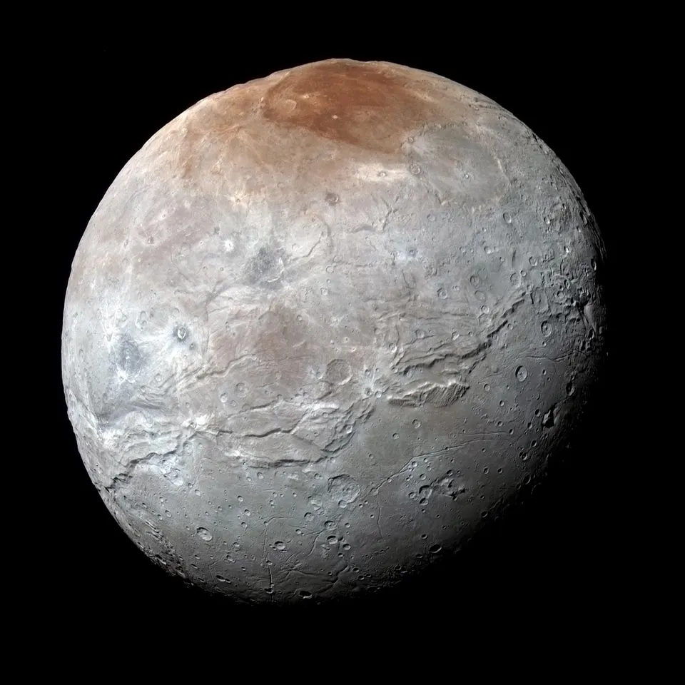 A grey, fractured moon with a rust-red patch at the top.